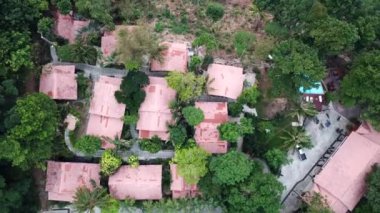 Yeşil Chang adası Kamboçya 'daki bir yangından dolayı dumanla kaplandı. Yeşil ağaçlar, palmiye ağaçları ve tepeler sis bulutlarıyla kaplıdır. Oteller denizin önündeki bir uçurumun üzerinde duruyor. Turkuaz su.