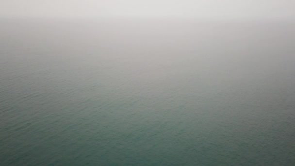 A kambodzsai tűz miatt a nagy füst elhomályosítja a láthatóságot a tengerben. Semmi sem látszik, csak egy sötét tenger és egy fehér köd. Repülés a tengerbe, horizont. Lövöldözés egy drónról. Félelmetesen.. — Stock videók
