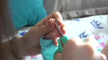 Bir anne yeni doğmuş bir çocuğun tırnaklarını keser..