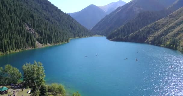 ทะเลสาบ Kolsay ท่ามกลางเนินเขาสีเขียวและภูเขา . — วีดีโอสต็อก