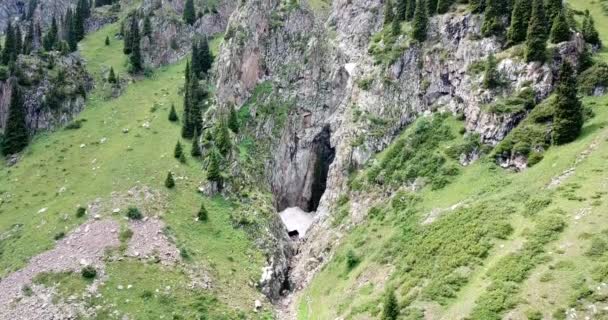 Černý vodopád v rokli s ledovou jeskyní. — Stock video