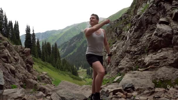 Guy in the mountains takes off his medical mask. — Stock Video