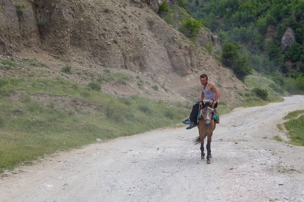 En man som reser på en sadlade, liten häst. — Stockfoto