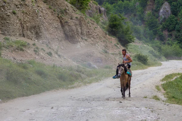 En man som reser på en sadlade, liten häst. — Stockfoto