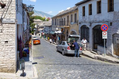 İnsanlar tarihi kent Gjirokaster Gjirokasteron ana cadde üzerinde.