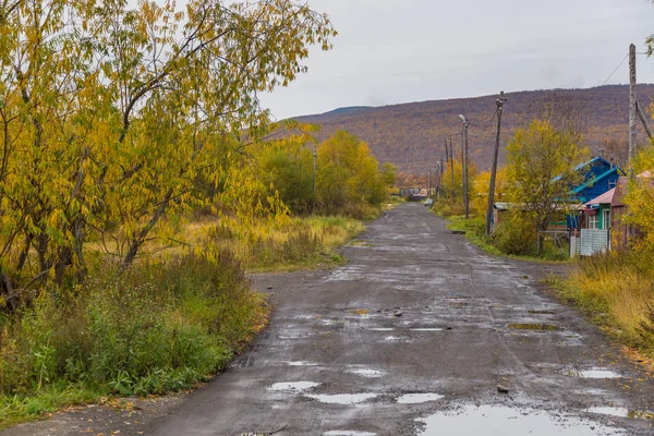 Coches en una carretera de grava, con agujeros y charcos, Sokoch, Rusia . — Foto de Stock