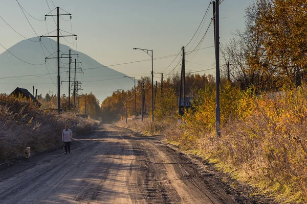 Pobres edificios de madera, peatonal y perro en la carretera, Kozyriewsk, Rusia . — Foto de Stock