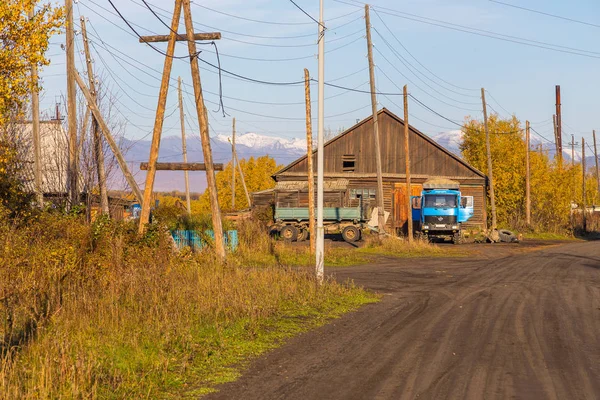 Pobres edificios de madera, gente y coche en la carretera, Kozyriewsk, Rusia . — Foto de Stock