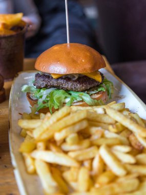 Beyaz tabakta cips ile taze burger.