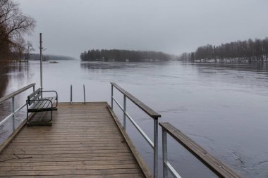 Ruotsalainen Gölü kıyısındaki küçük iskele, kışın bulutlu, Finlandiya.