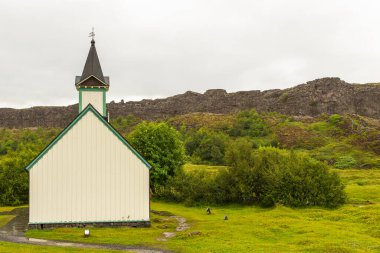 Thingvellir, İzlanda - 22 Ağustos 2015: Thingvellir Ulusal Parkı mezarlığındaki beyaz kilisenin ve çevresindeki binaların manzarası.