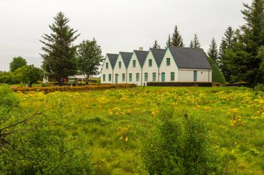 Thingvellir, İzlanda - 22 Ağustos 2015: Thingvellir Ulusal Parkı mezarlığındaki beyaz kilisenin ve çevresindeki binaların manzarası.
