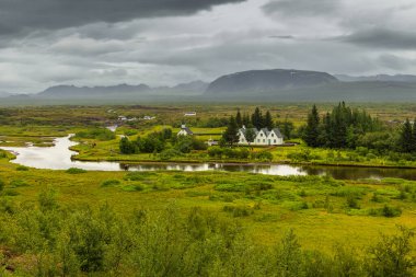 Thingvellir, İzlanda - 22 Ağustos 2015: Thingvellir Ulusal Parkı mezarlığındaki beyaz kilisenin ve çevresindeki binaların manzarası.