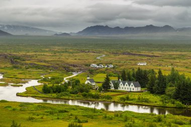 Thingvellir, İzlanda - 22 Ağustos 2015: Thingvellir Ulusal Parkı mezarlığındaki beyaz kilisenin ve çevresindeki binaların manzarası.