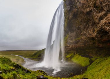 Seljalandsfoss, İzlanda 'nın Güney Bölgesi' nde şelale, Seljalands Nehri 'nin kaynağının volkan buzulu Eyjafjallajokull' a ait bir parçası..
