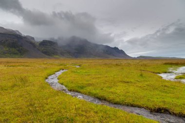 Vatnajokull Ulusal Parkı 'ndaki Skaftafell Buzulu' ndan küçük bir nehir akar. Güneydoğu İzlanda.
