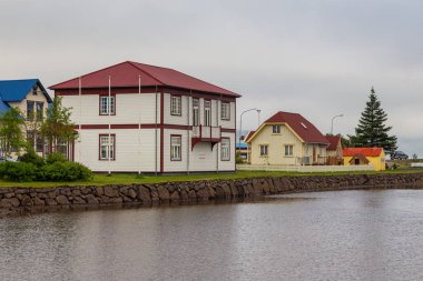 Seydisfjordur, İzlanda - 24 Ağustos 2015: Fiyort yakınlarındaki Seydisfjordur limanındaki ahşap binalar. Arkaplanda dağlar.
