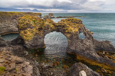 Rocky basalt cliffs on the south coast of the Snaefellsnes peninsula. Gatklettur rock formation. Arnarstapi, Western Iceland. clipart