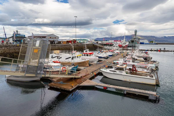 Reykjavik, İzlanda - 27 Ağustos 2015: Başkentteki liman binaları ve demirlemiş tekneler. Arka planda dağ.
