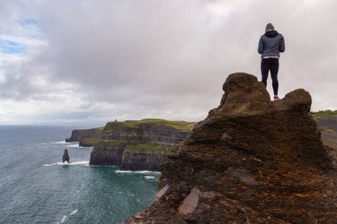 Moher, Burren Yolu, Ireland- 07 Kasım 2015: Clare İlçesi 'nin Burren bölgesinin kıyısındaki Moher' in uçurumlarında yürüyen ve kalan insanlar,.