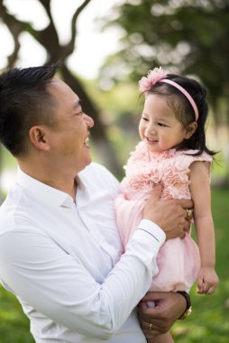 Parktaki Asyalı baba ve kızı. 