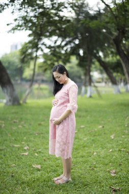 Parktaki mutlu hamile kadın.