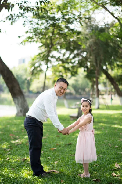 Parktaki Asyalı baba ve kızı. 