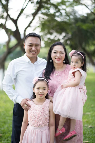 快乐的亚洲怀孕家庭在公园里 图库照片