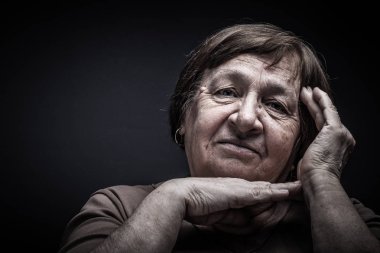 Yaşlı kadın ile el yüz yakınındaki stüdyo portre. Gülümse. Tonda.