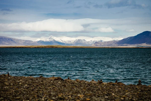 Fırtınalı denizde ve İzlanda'daki karlı dağlar.