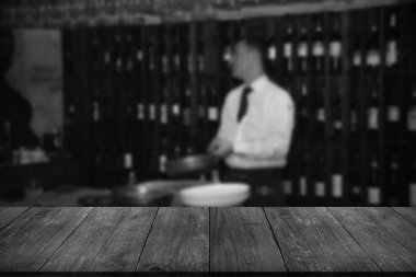 Bulanık bir mutfak nerede adam yemek yapar üzerinde koyu ahşap tablodan görüntüleyin. Tonda.