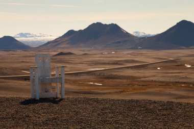 İzlanda'nın taşlık kayalık çöl manzara üzerinde yaratıcı büyük ahşap sandalye.