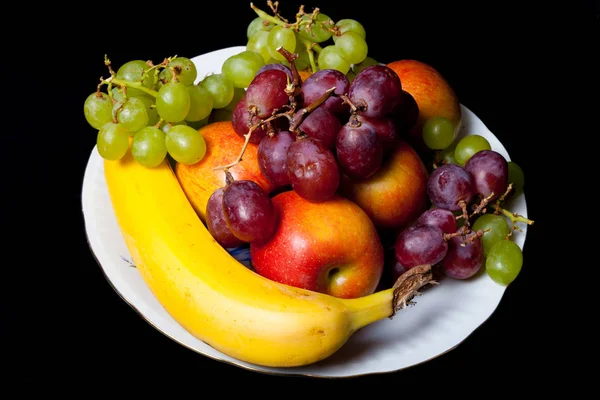 Diferentes Tipos Frutas Uma Placa Cerâmica Branca Fundo Preto — Fotografia de Stock
