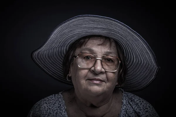 Retrato Estúdio Mulher Idosa Com Óculos Chapéu Sorri Tonificado — Fotografia de Stock