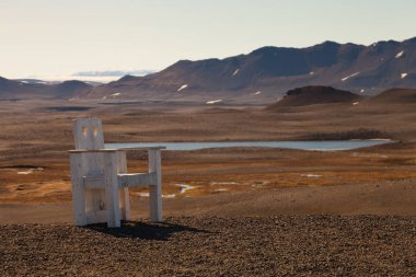 İzlanda'nın taşlık kayalık çöl manzara üzerinde yaratıcı büyük ahşap sandalye.