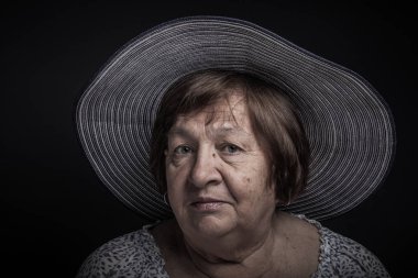 Yaşlı kadın şapka ile stüdyo portre. Sakinlik. Tonda.