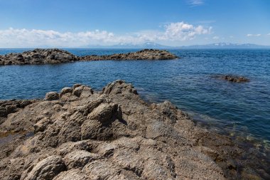 Cape Stolbchaty. Cape Kunashir Adası batı kıyısında. Mendeleyev volkanın bazaltik lavaş katmanların oluşur.