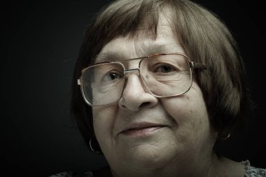 Yaşlı kadın gözlük ile stüdyo portre. Sakinlik. Tonda.