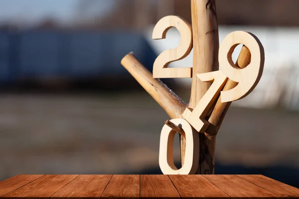 木製のテーブル 背景には 木の節点にハングアップして番号 2019 — ストック写真