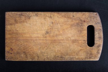 Kesme tahtası siyah bir arka plan el yapımı yandı. Sert ahşap tahta yıpranmış.