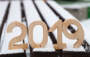 Ahşap figürler 2019 karlı bankta. Yeni yıl ve Noel Tema.