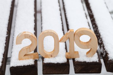 Ahşap figürler 2019 karlı bankta. Yeni yıl ve Noel Tema.