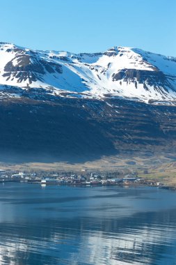 Icela fiyortundaki küçük kasaba ve karlı dağların manzarası