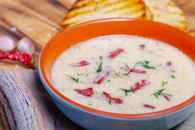 Ekşi krema, ekmek ve yanmış ahşap ta baharat ile baharatlı çorba