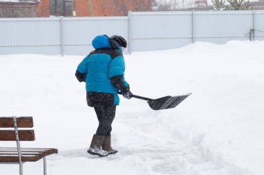 Sıcak mavi ceketli yaşlı kadın kar yağıyor