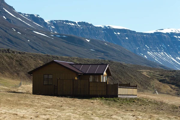 Pequeña casa y montañas nevadas en el fiordo de Islandia — Foto de Stock