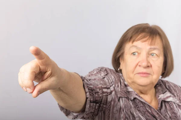 Yüzgecinle bir şeyi işaret eden yaşlı bir kadının portresi — Stok fotoğraf