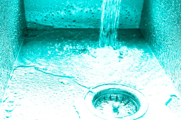 Fluxo de água em uma pia de metal em uma cozinha moderna. Tonificado — Fotografia de Stock