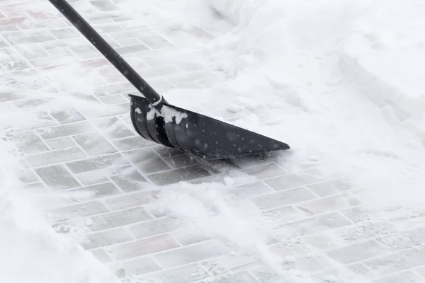 Schneeschaufel auf einem Fliesenboden — Stockfoto