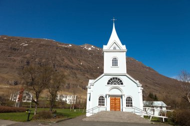 İzlanda fiyortlarında küçük bir köyde beyaz bir kilise.